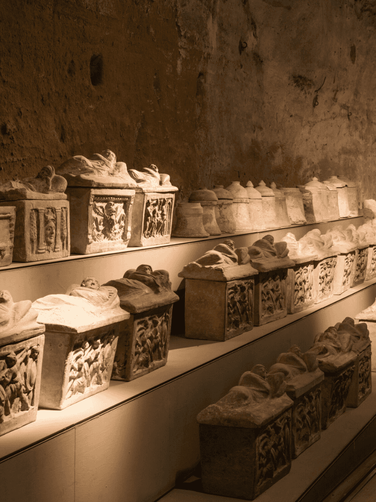 Ancient carved stone sarcophagi displayed in a historical museum exhibit.