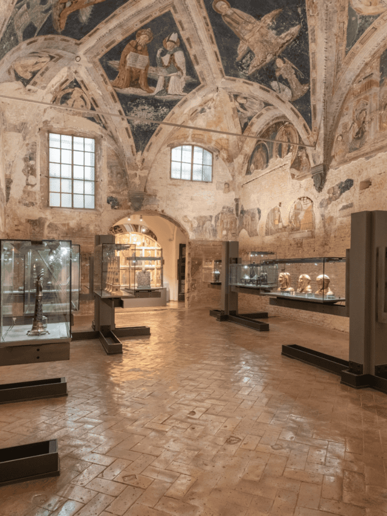Ancient museum with historical artifacts and frescoed ceilings showcasing medieval art and culture.