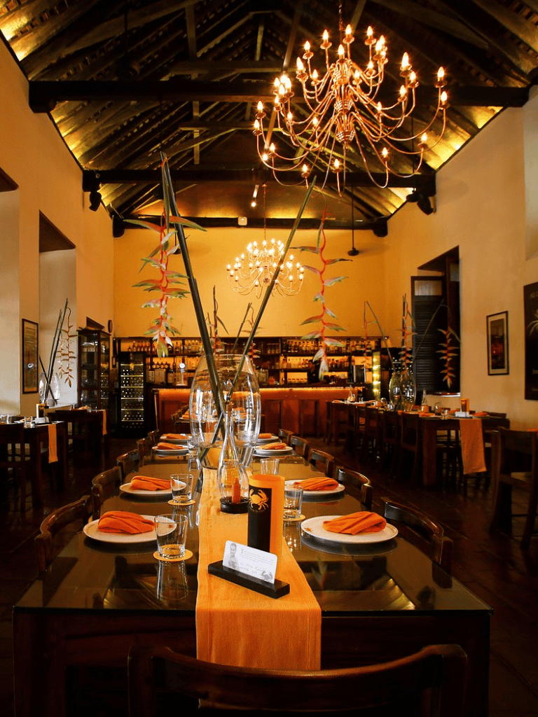 Elegant restaurant interior with chandeliers, floral centerpieces, and warm lighting for fine dining experiences.