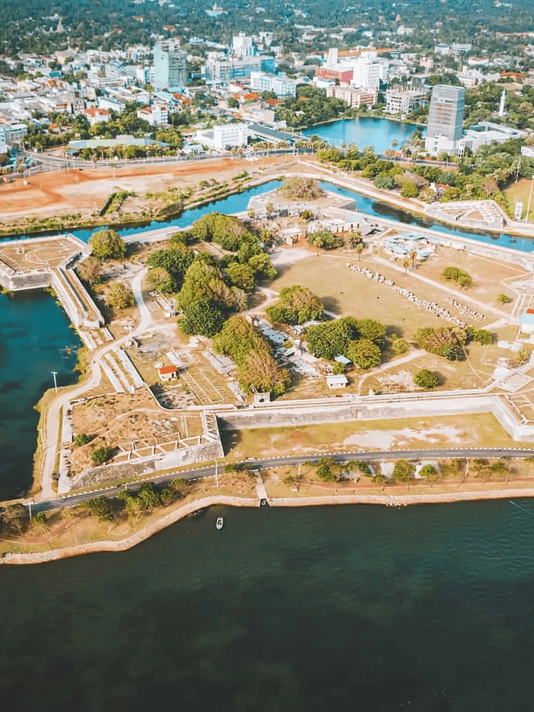 Aerial view of Quest for Directions park with lakes and city skyline in the background.