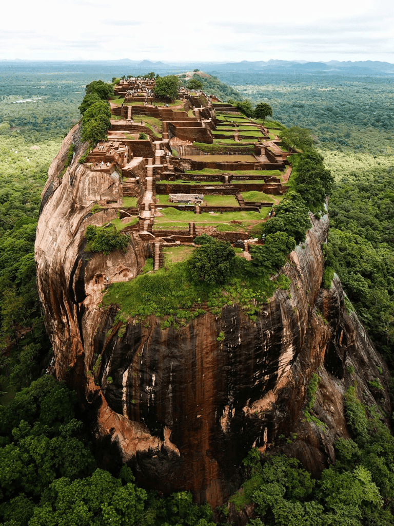 Ancient rock fortress of Sigiriya surrounded by lush greenery in Sri Lanka.