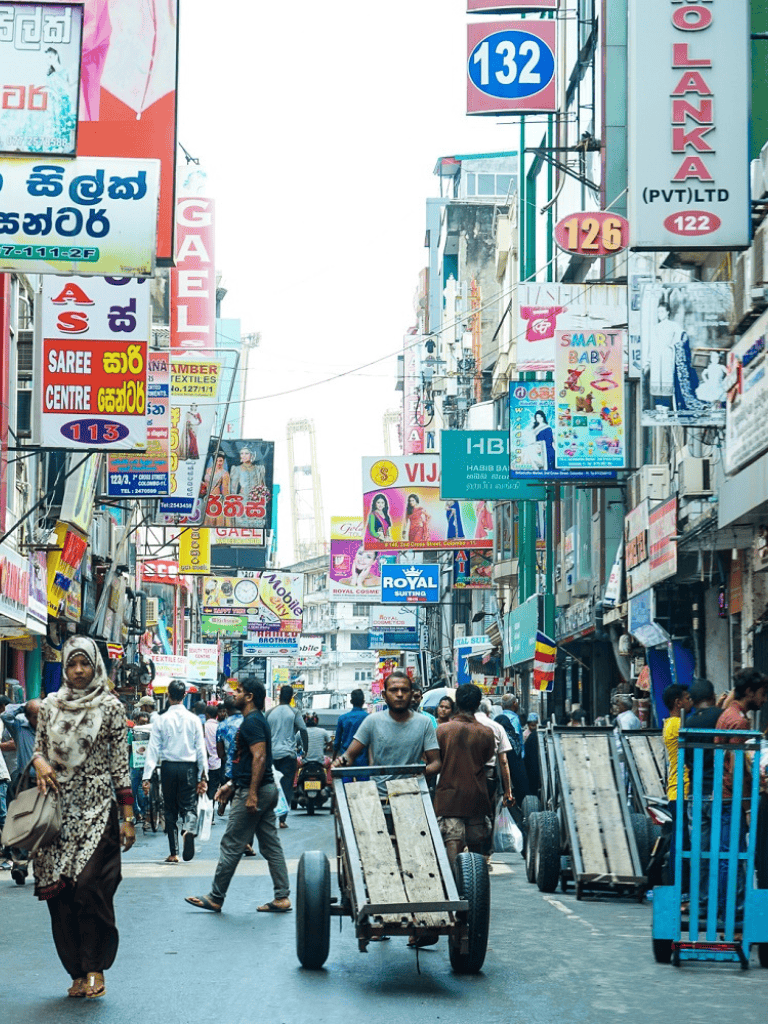 Busy urban street scene with vibrant signs and pedestrians in a bustling city.