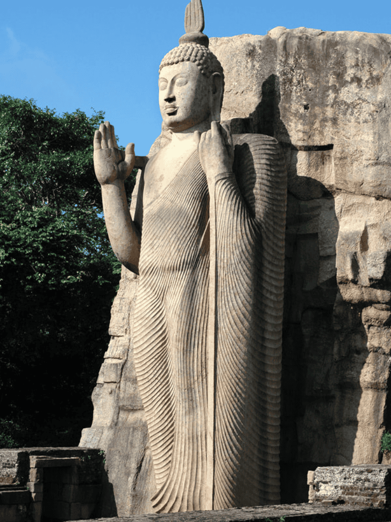 Majestic ancient stone Buddha statue at Sigiriya, Sri Lanka, with detailed carvings and serene expression.
