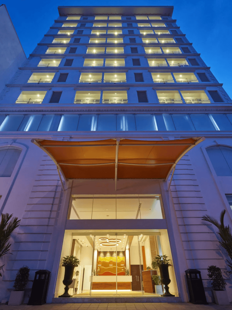 Elegant hotel building with modern design and illuminated windows at dusk.