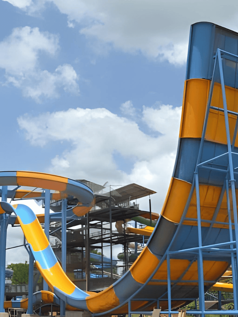 Colorful outdoor water slides at Quest for Directions amusement park in bright blue and yellow, perfect for family fun and adventure.