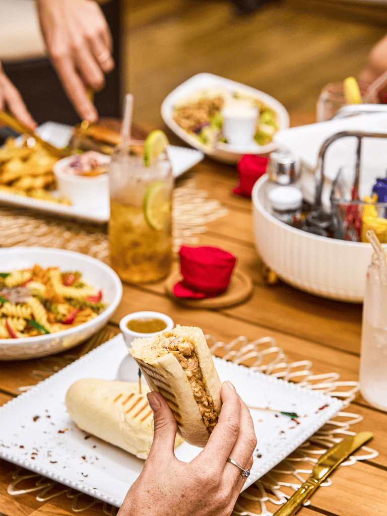 Delicious turkey club sandwich with side dishes at a cozy restaurant table.