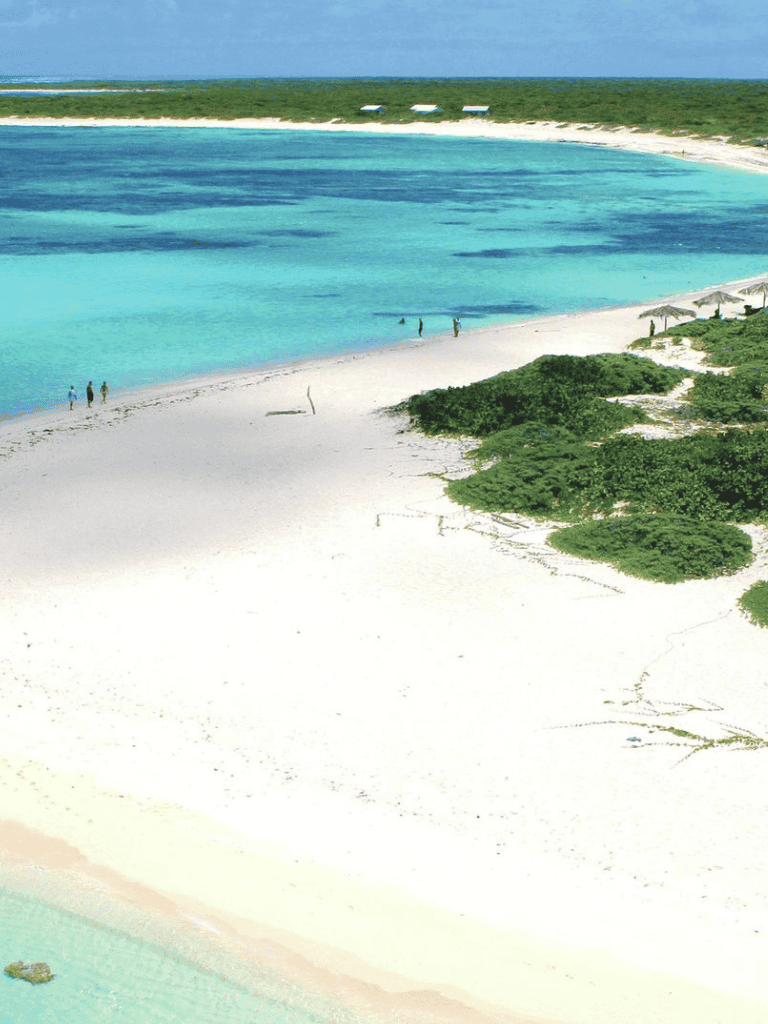 Azure beach with turquoise waters and white sandy shoreline, perfect for vacations and leisure.
