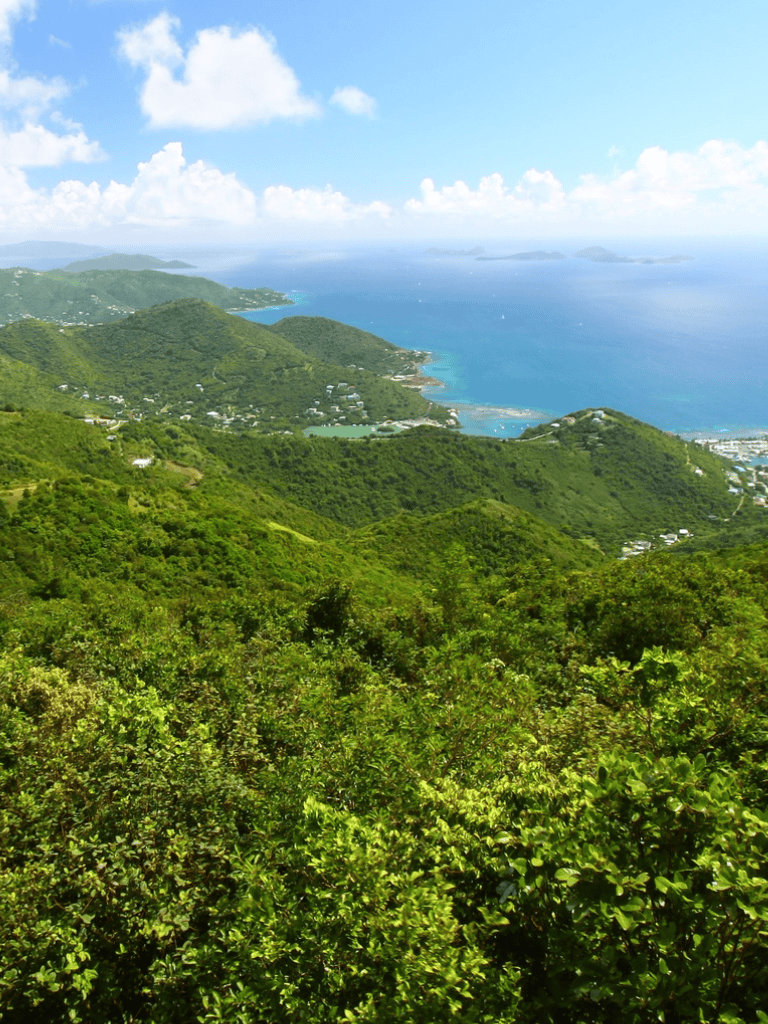 Breathtaking coastal view from lush green mountains overlooking the ocean and islands.