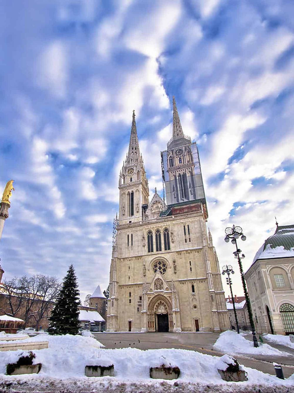 Majestic Gothic cathedral with snow-covered surroundings, perfect for travel and architecture enthusiasts exploring Europe.