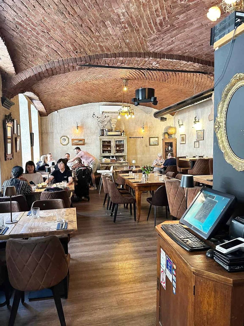 Cozy restaurant interior with exposed brick arches, vintage decor, and warm lighting, perfect for dining and socializing.