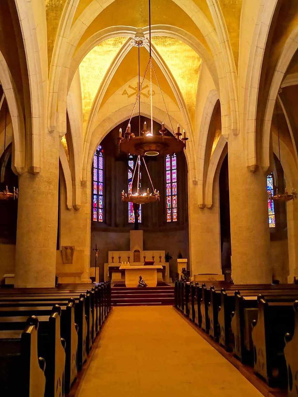 Historic church interior with stained glass windows and ornate architecture.
