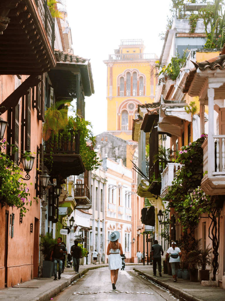 Colorful street in a historic town with vibrant buildings and lush greenery, perfect for travel and exploration.