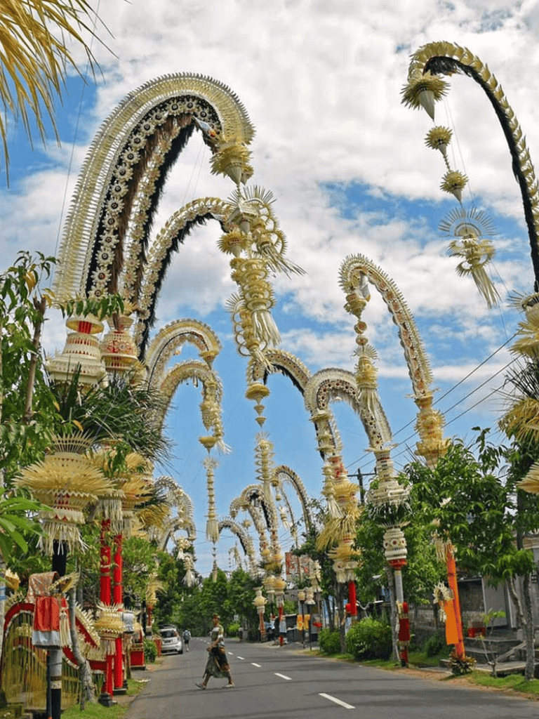 Colorful floral overhead decorations in a street parade, showcasing cultural celebration and vibrant community events.