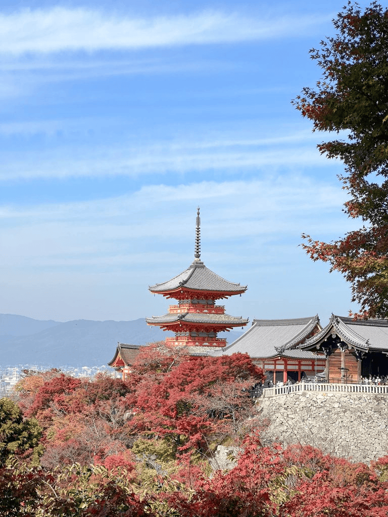 Traditional Japanese pagoda surrounded by autumn foliage in Kyoto, Japan.