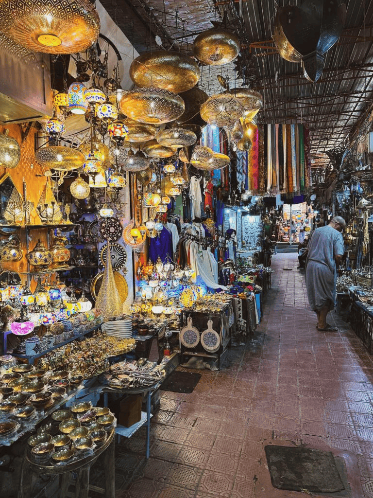Vibrant marketplace with brass lamps, textiles, and souvenirs for travelers and explorers.