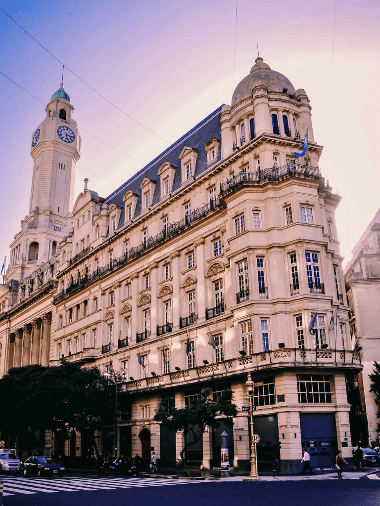 Luxury Parisian building with historic architecture and flags, downtown cityscape.