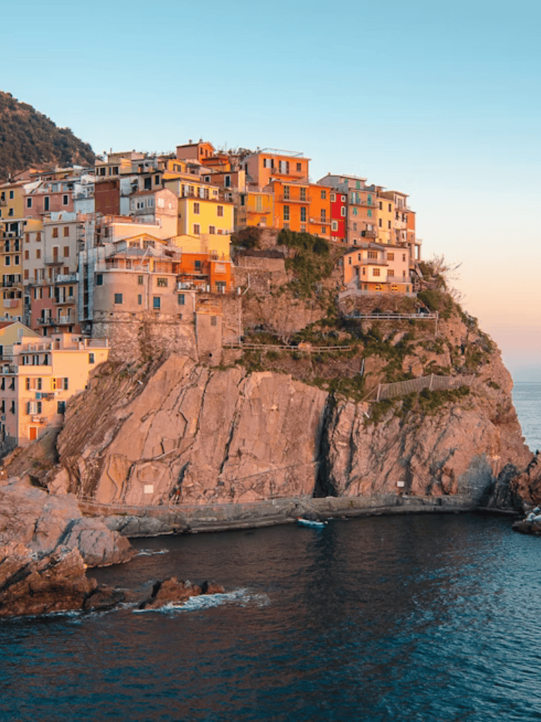 Colorful cliffside houses in Cinque Terre coastal Italy at sunset.