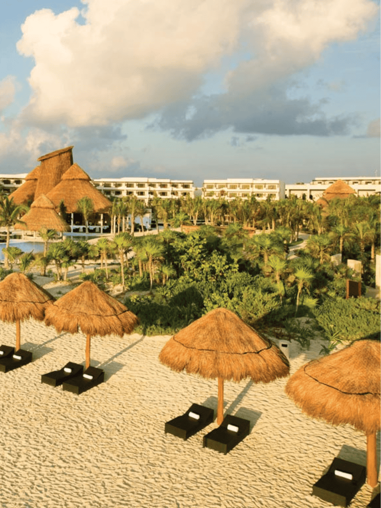 Relaxing beach resort with thatched umbrellas and lush tropical greenery. Perfect for vacations and leisure.