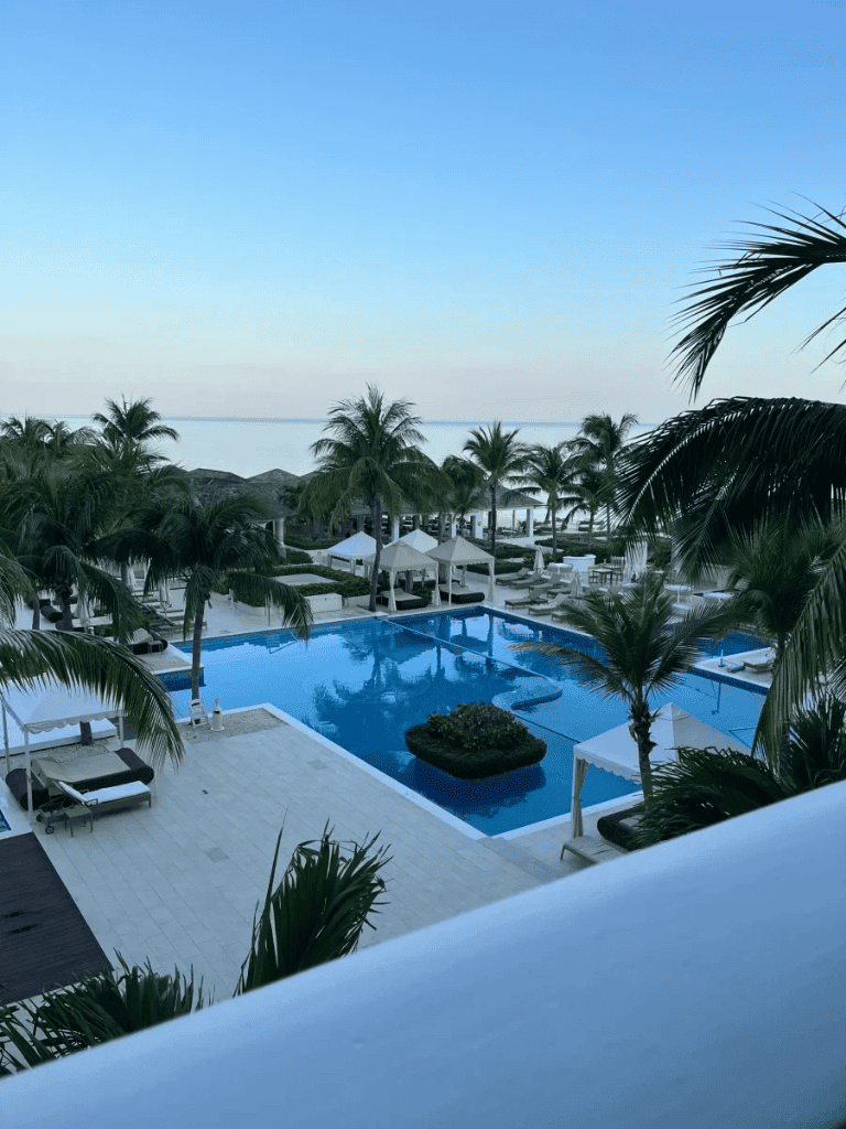 Elegant tropical poolside view at QuestForDirections resort, surrounded by palm trees and beach cabanas.