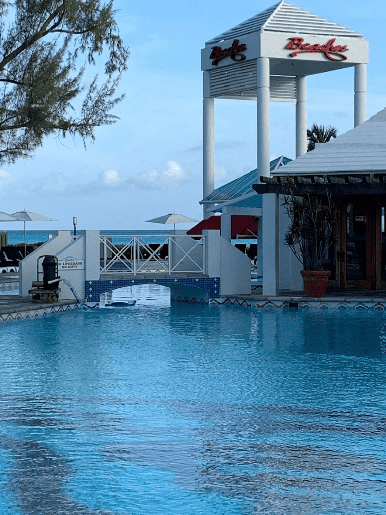 Poolside view at QuestForDirections beach resort with ocean in background.
