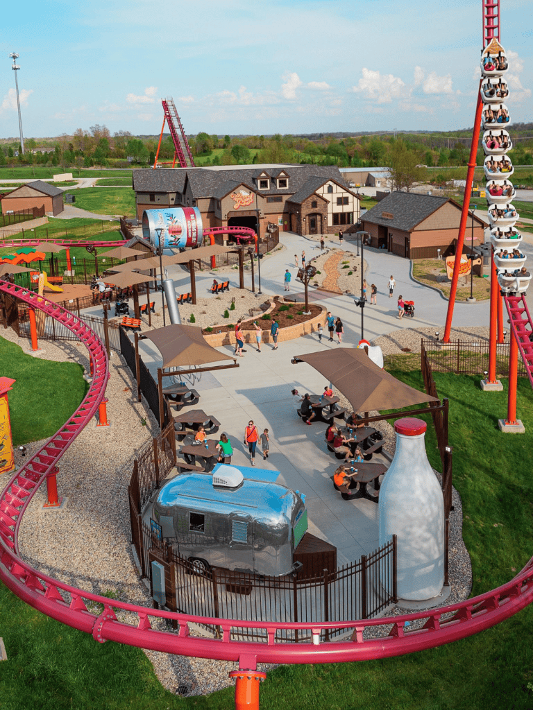 Colorful amusement park with roller coaster, dining area, and engaging attractions for family fun.