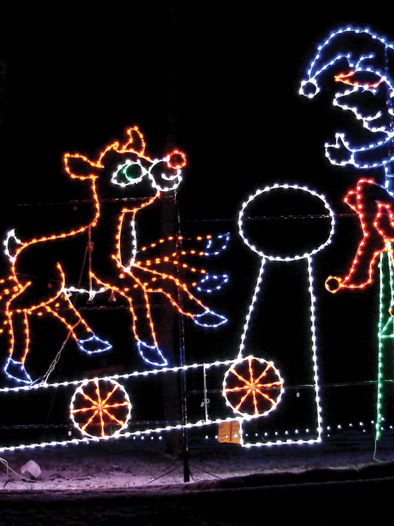 Bright festive holiday lights display featuring a unicorn, Santa, and a toy train in vibrant neon colors.