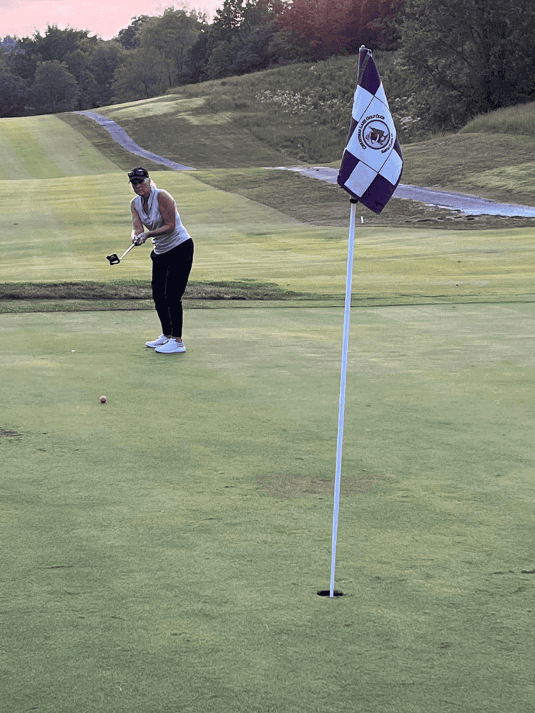 Golf player preparing to putt on the green at Quest for Directions golf course.