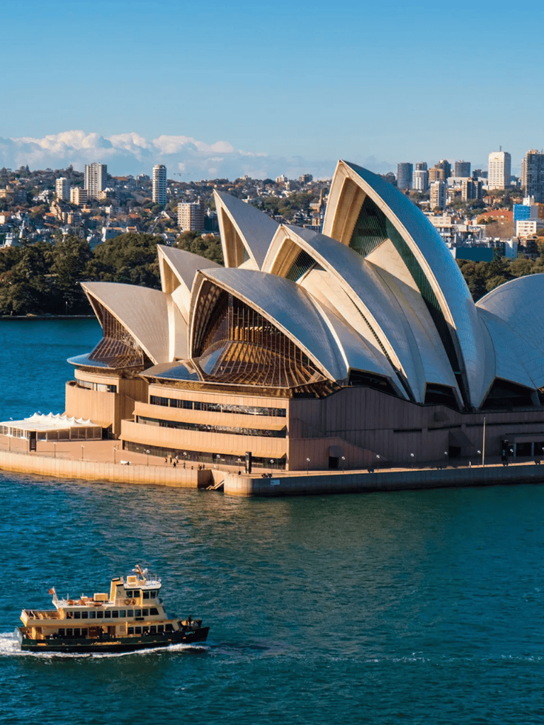 Sydney Opera House with harbor view and city skyline, iconic Australian landmark and top tourist destination.