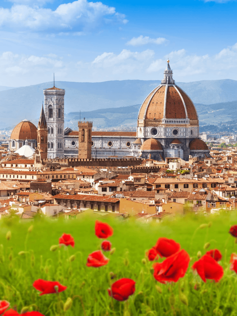 Stunning view of Florence with the Florence Cathedral, iconic red poppies in the foreground, mountain backdrop, Italy travel destination.
