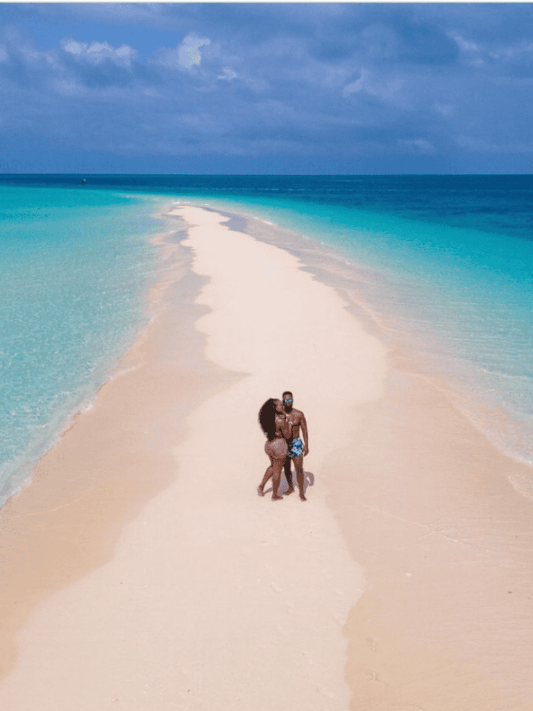 Secluded tropical beach with clear turquoise waters and white sand, perfect for tranquil vacation escapes.
