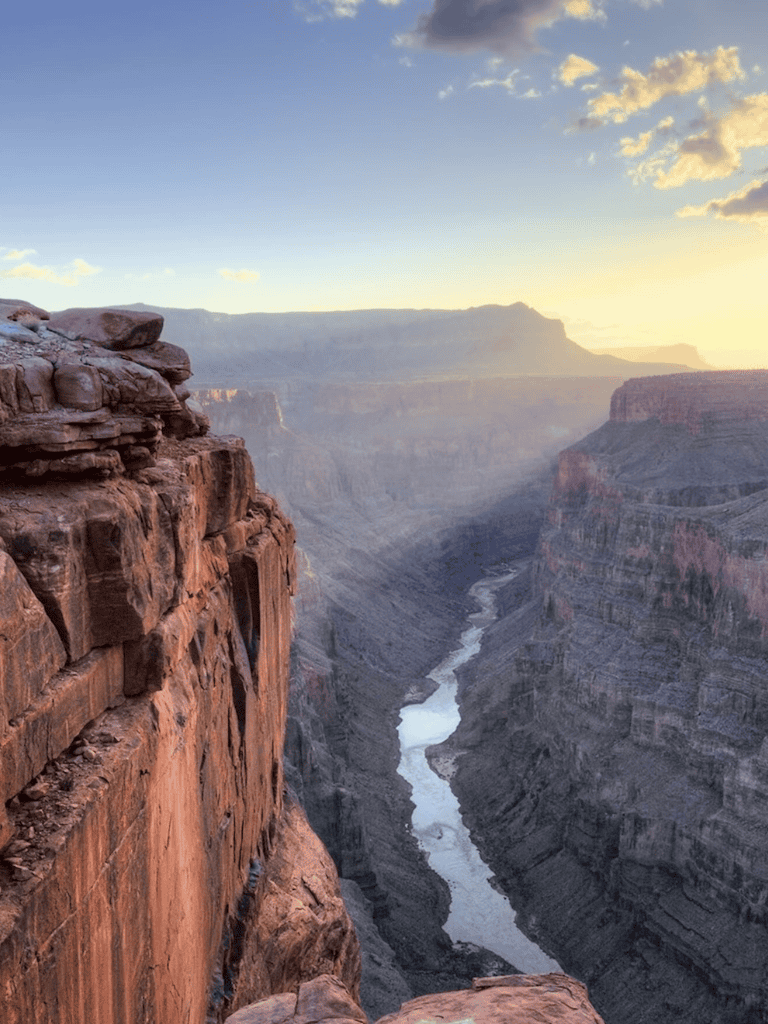 Majestic Grand Canyon at sunset, showcasing layered rock formations and Colorado River views.
