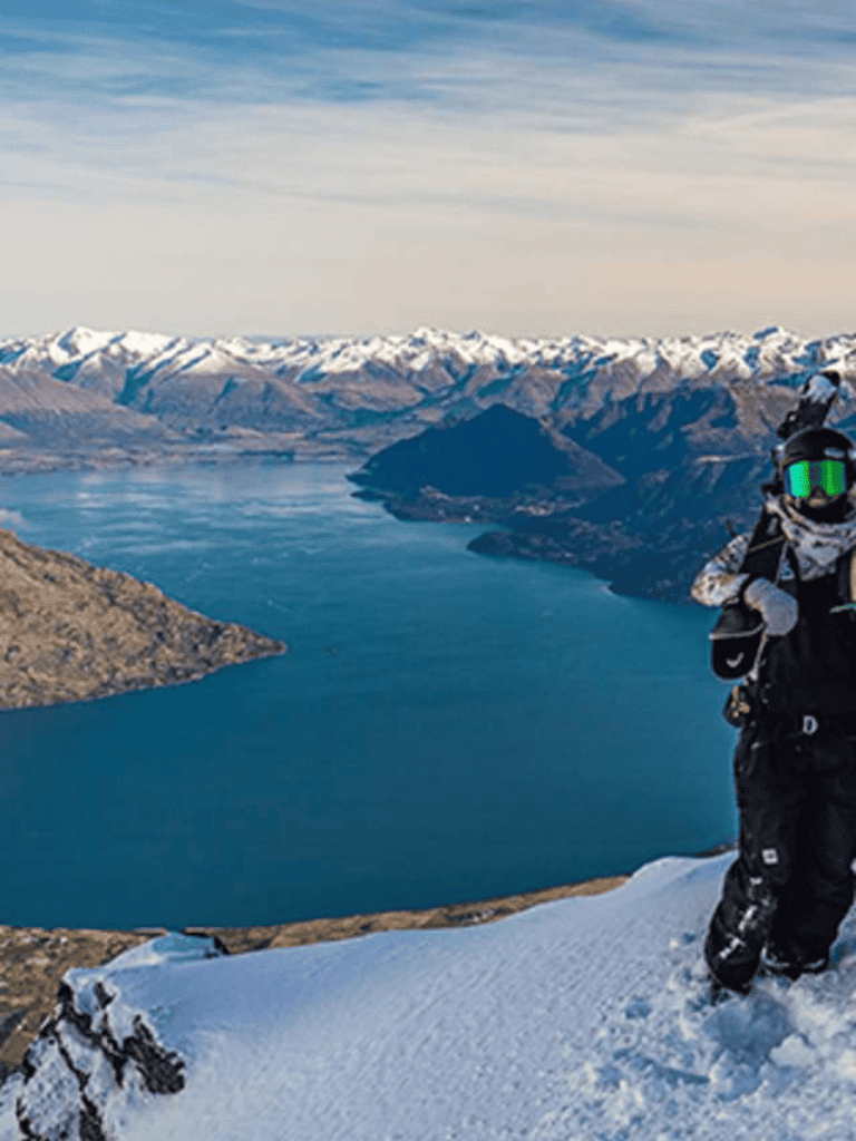 Breathtaking mountain landscape with snow-capped peaks and a clear blue lake, perfect for adventure seekers.