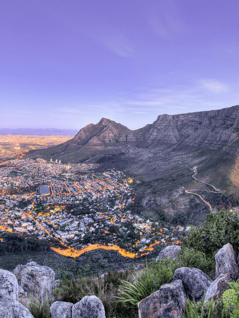 Panoramic view of Cape Town at dusk with Table Mountain in the background.