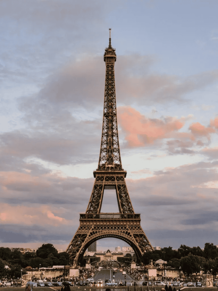 Vintage Eiffel Tower in Paris at sunset, iconic landmark with beautiful sky background.