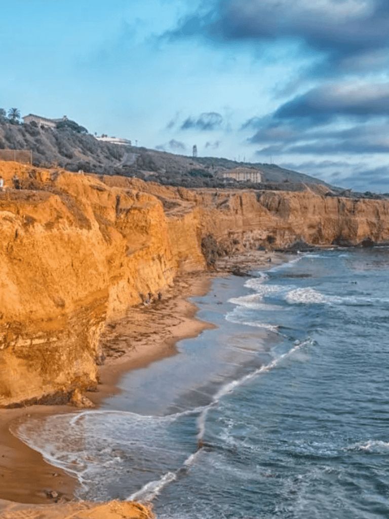 Cliffs and ocean shoreline at sunset with scenic coastal views.