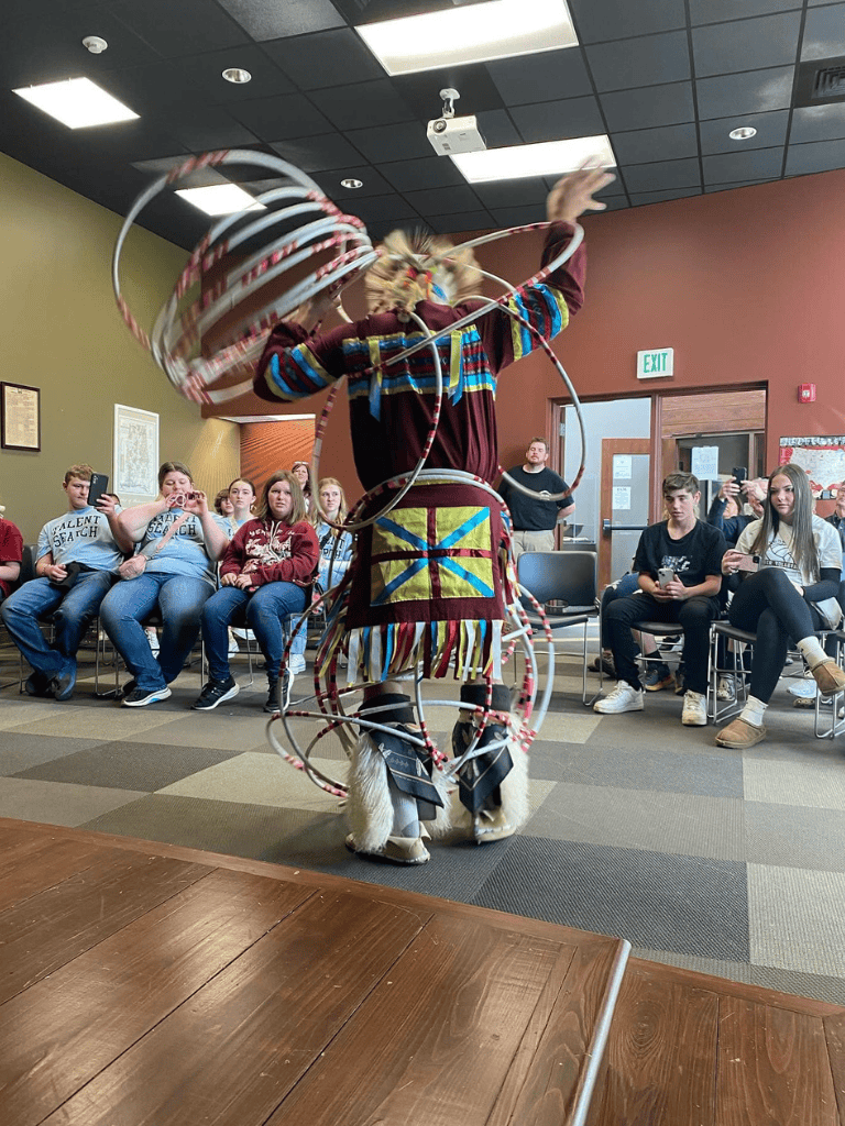 Colorful performer with hoops entertains students during Quest for Directions event.