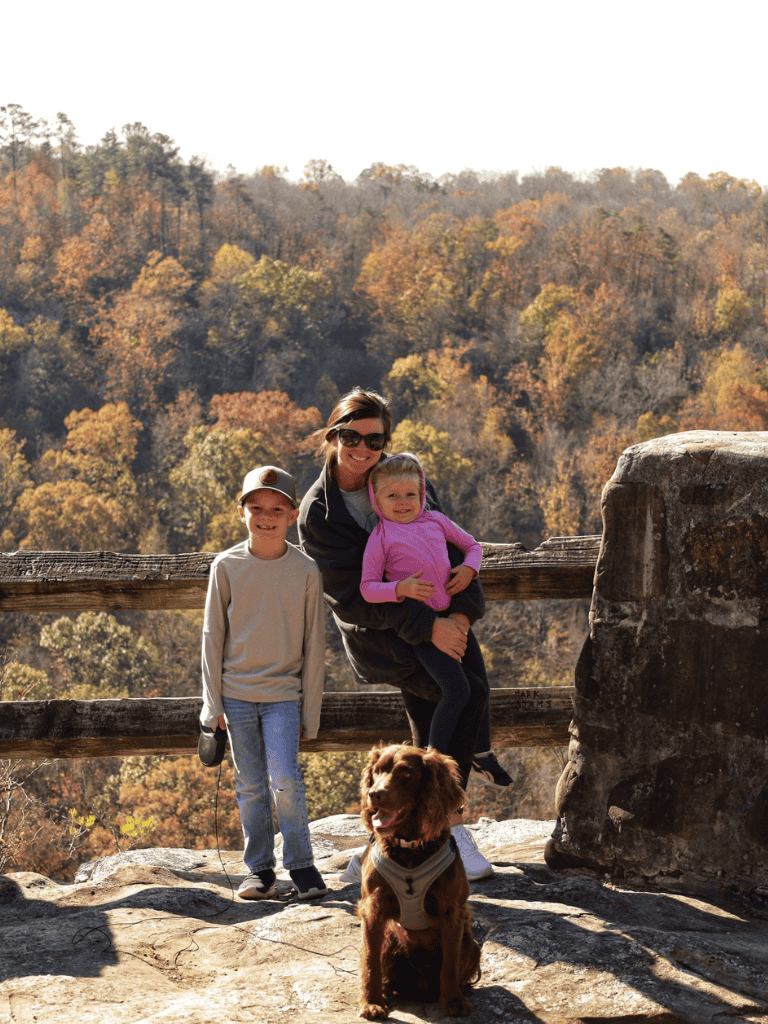Enjoying fall foliage and outdoor adventures with family at scenic mountain viewpoint.