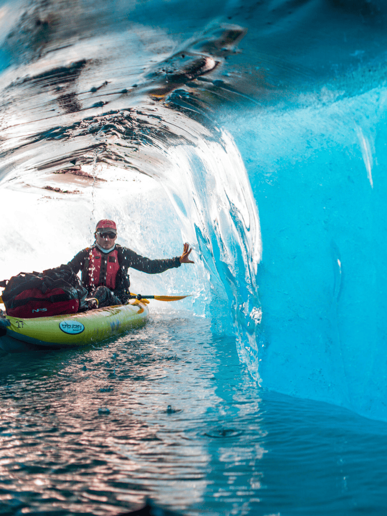Viking standing in kayak inside a large ocean wave during surf adventure.