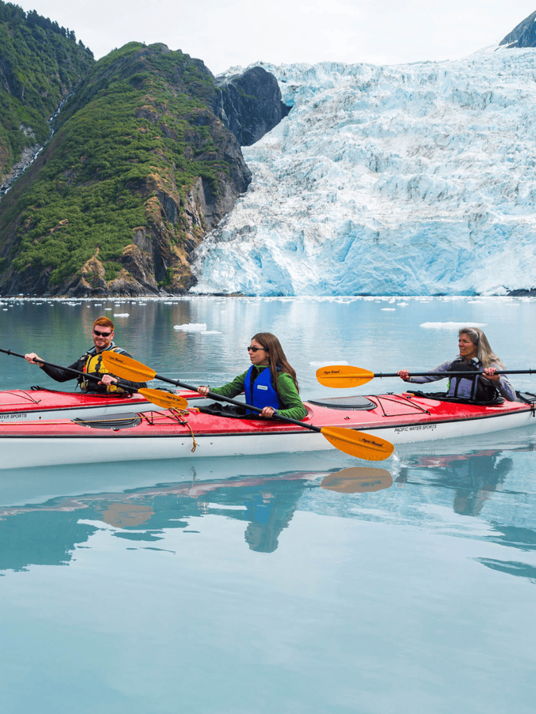 Adventure kayaking in glacier waters with scenic mountain and ice formations.