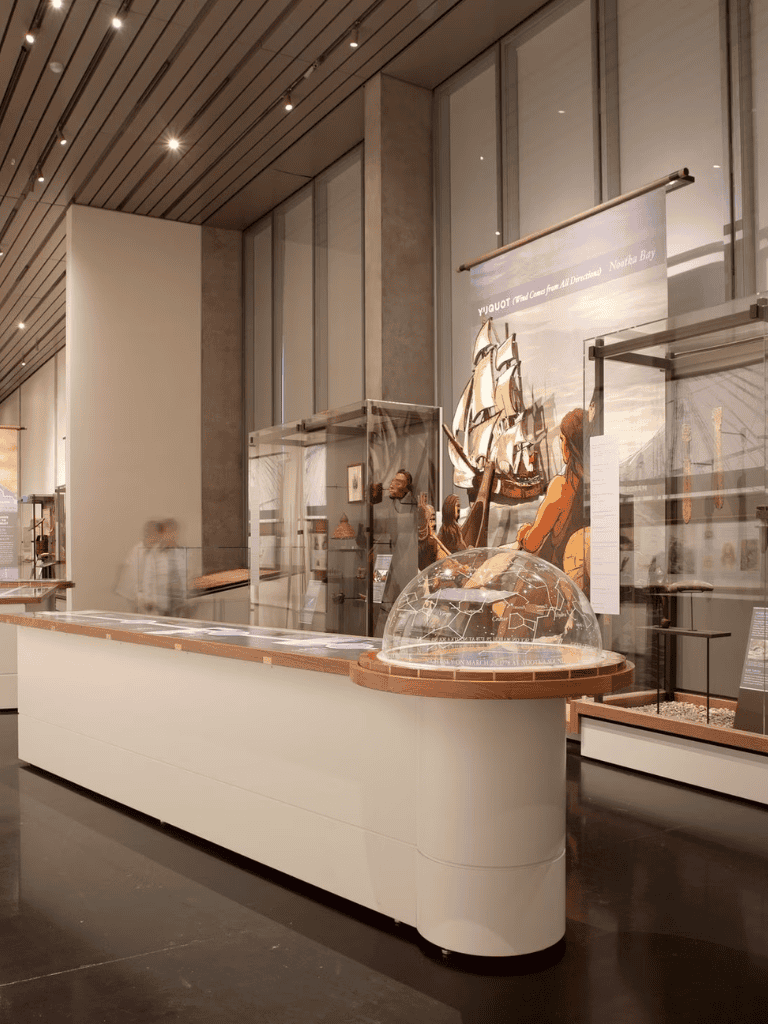 Exhibition museum display with ship models and historical artifacts in modern gallery setting.