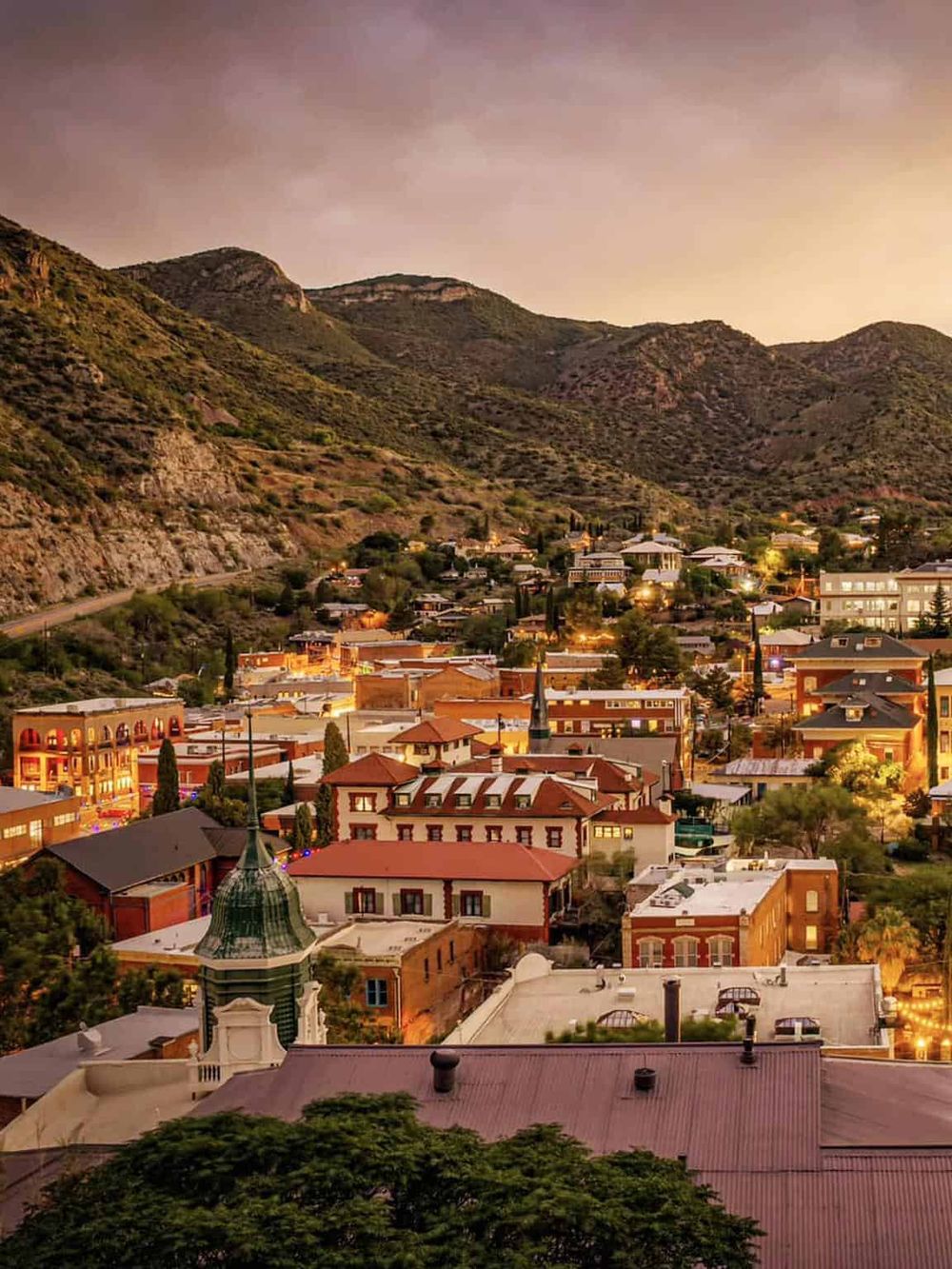 Charming mountain town during evening, showcasing historic architecture and scenic hillside views.