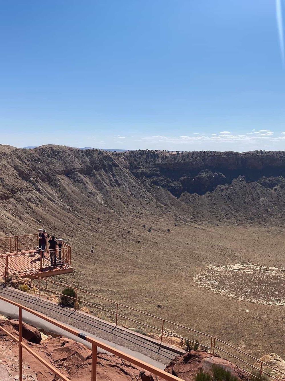 Barren volcanic crater with viewing platform and visitors, exploring adventure travel at QuestForDirections.