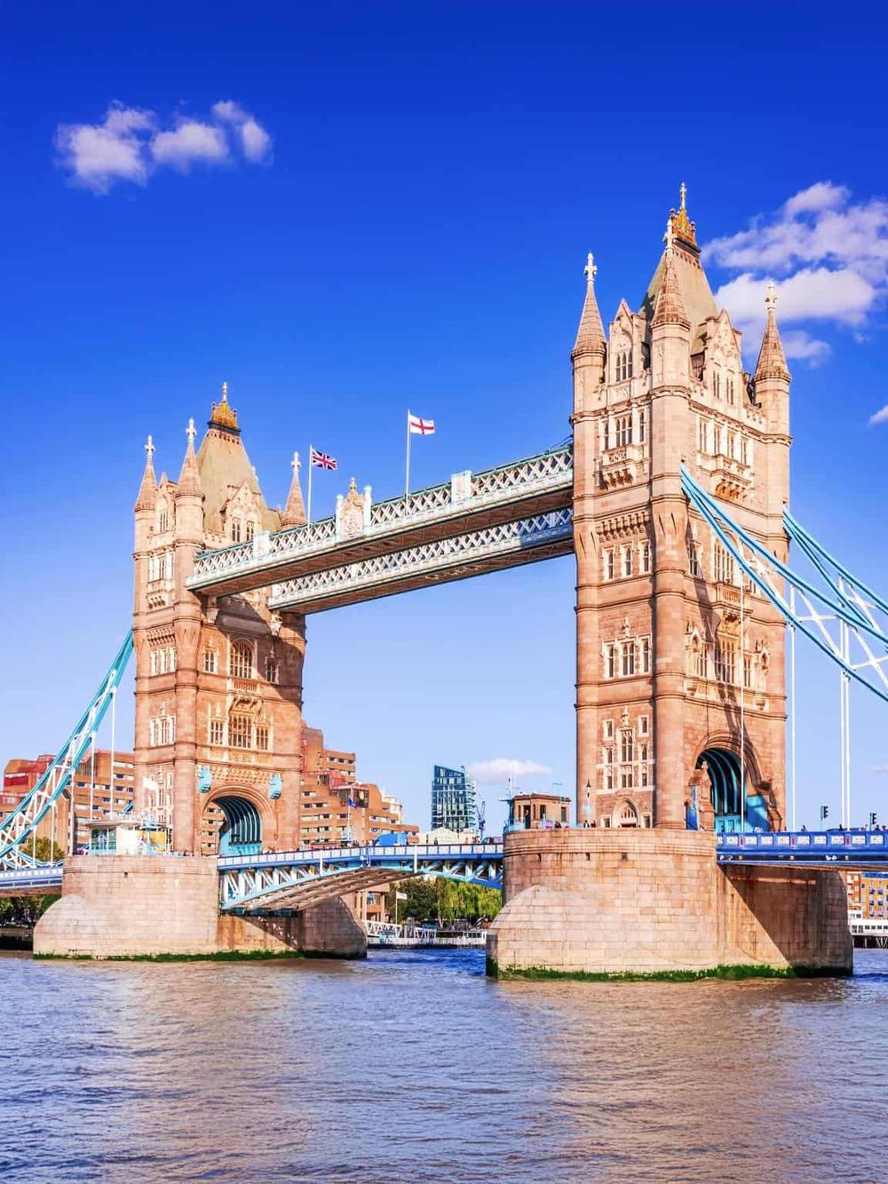 Iconic Tower Bridge in London against bright blue sky, a popular landmark and tourist attraction.