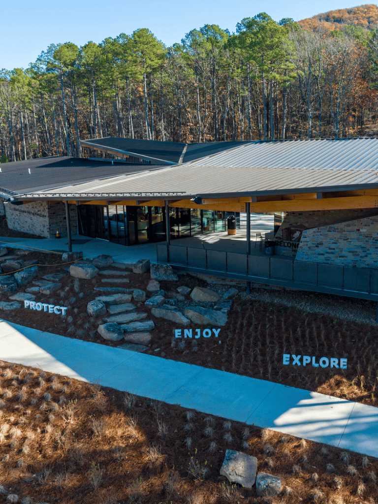 Modern visitor center with scenic outdoor landscape and motivational signage for outdoor exploration.