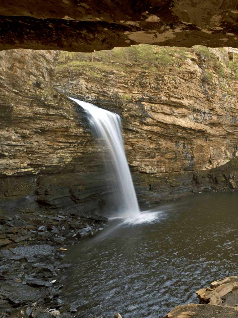 Waterfall cascading over rocky cliffs in natural scenic landscape.