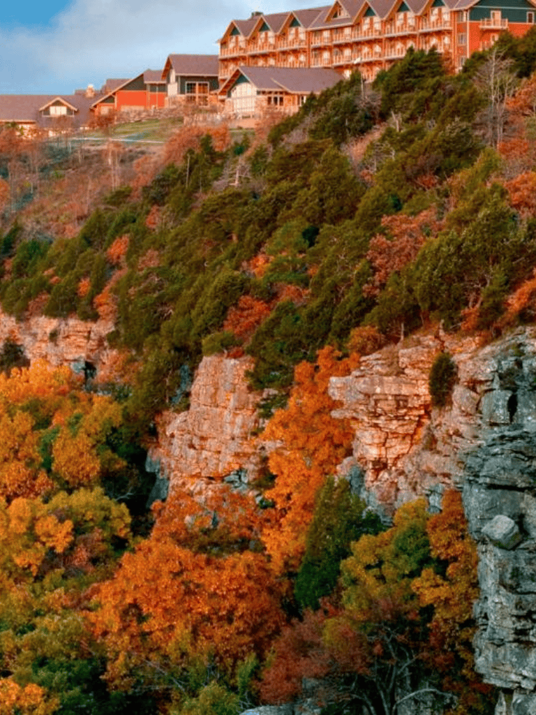 Autumn mountain resort with colorful fall foliage and wooden lodges on a hillside.
