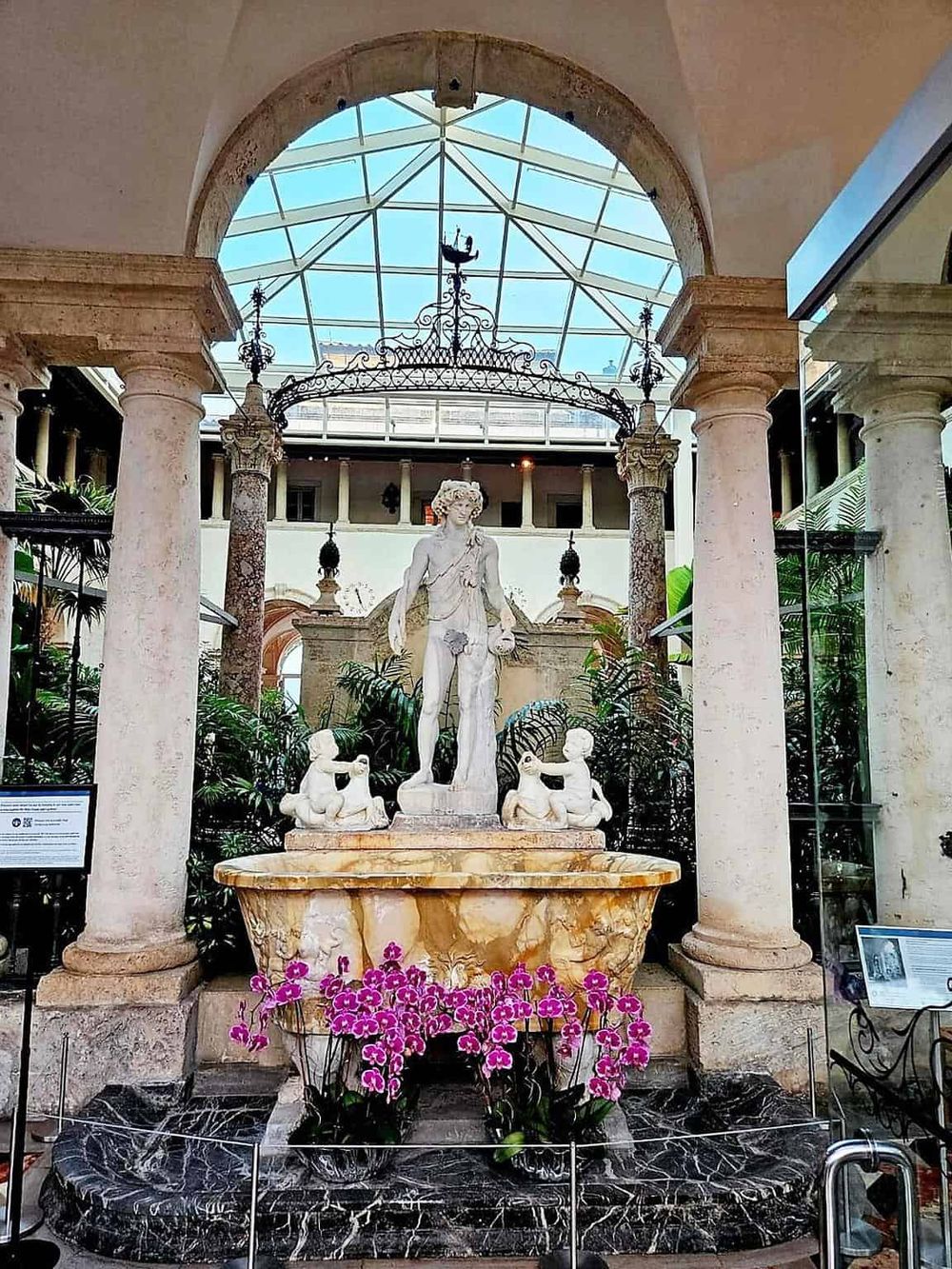 Elegant marble fountain featuring classical statues in a luxurious indoor hotel atrium.