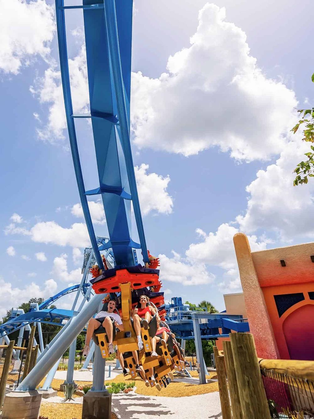 Thrilling roller coaster ride at Quest for Directions amusement park in bright daylight.