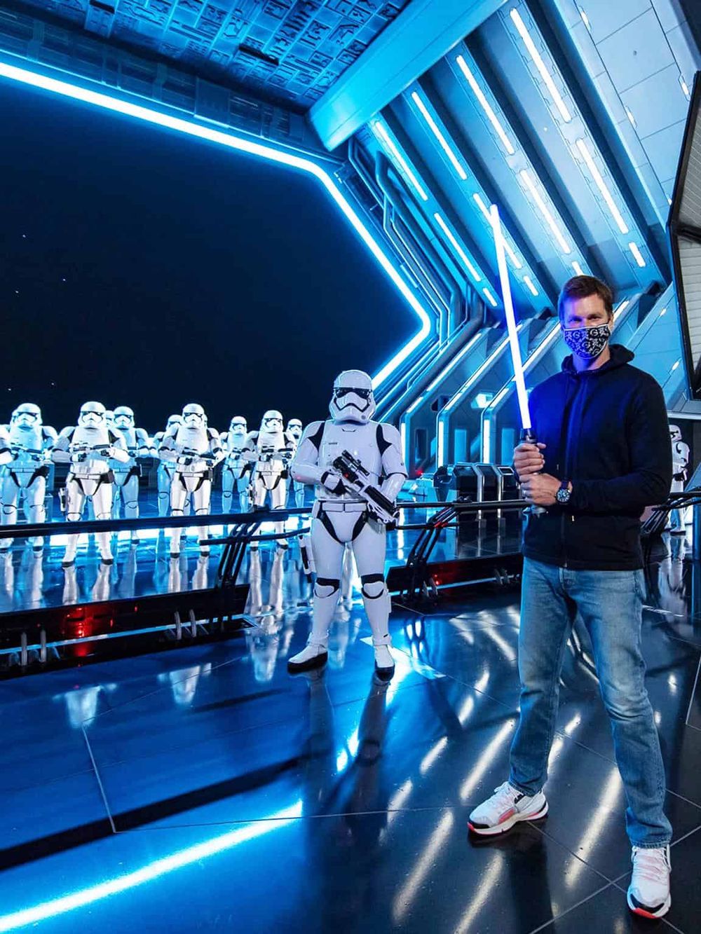 Futuristic Star Wars themed experience with Stormtroopers and a person holding a blue lightsaber at QuestForDirections.