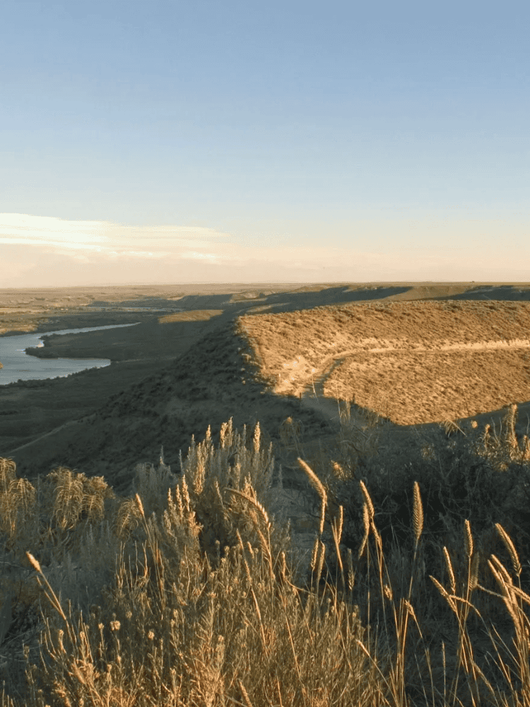 Sweeping landscape of hills and river at sunset, outdoor nature scenery, scenic view.